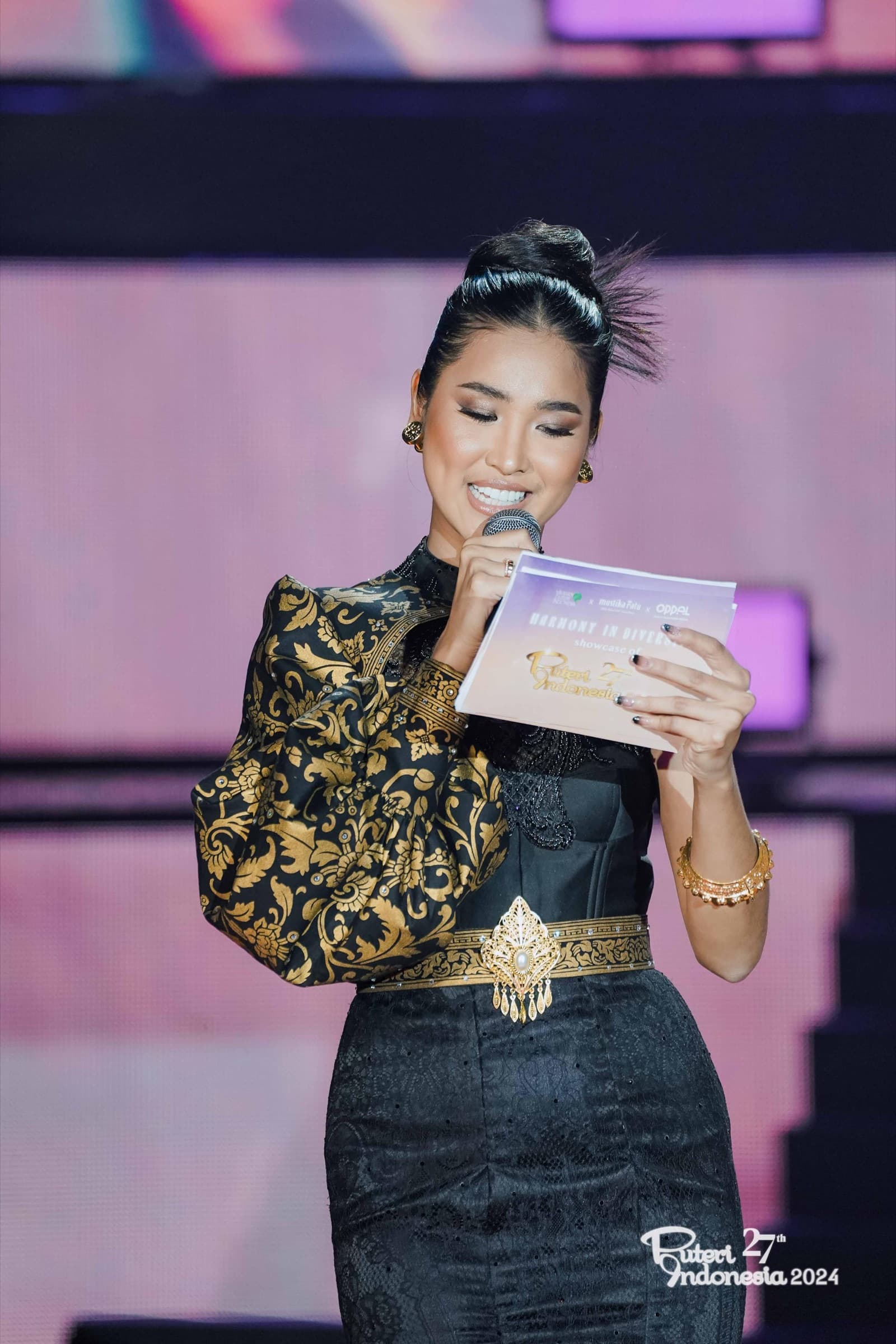 Speaker on stage holding a microphone